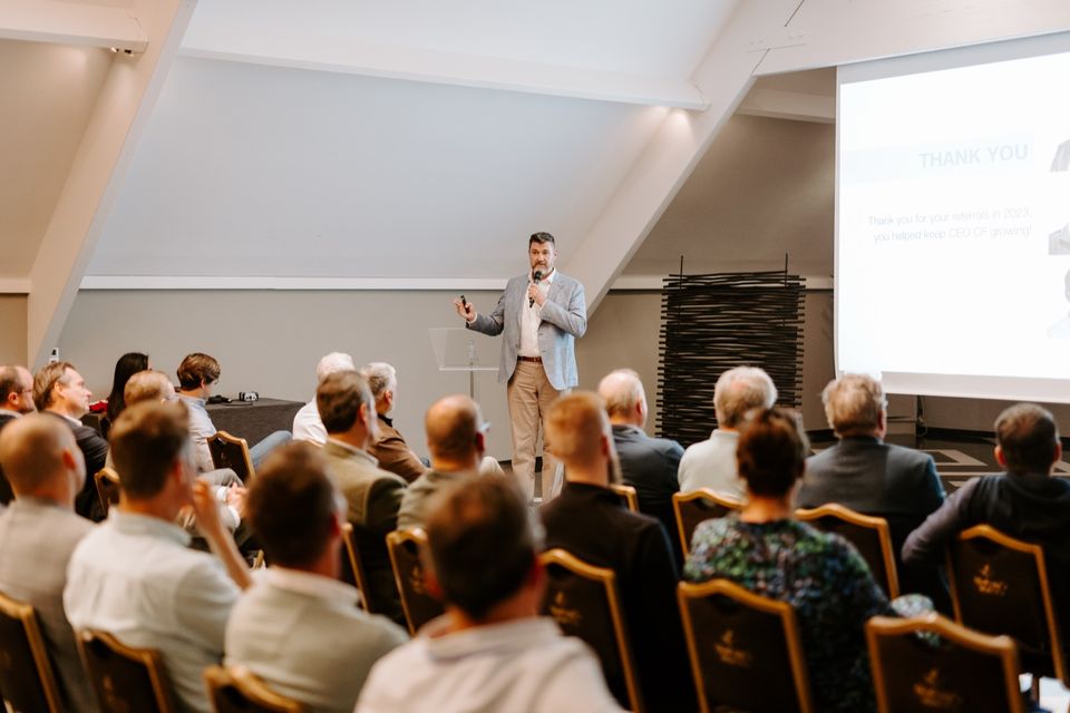 Tony Wood presenting to a full conference room